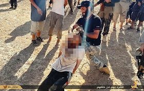 A jihadist appears holds a terrified man by his hair
and begins to slice through his neck